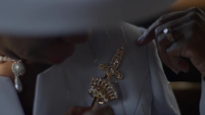 A woman pins a broach to her shirt