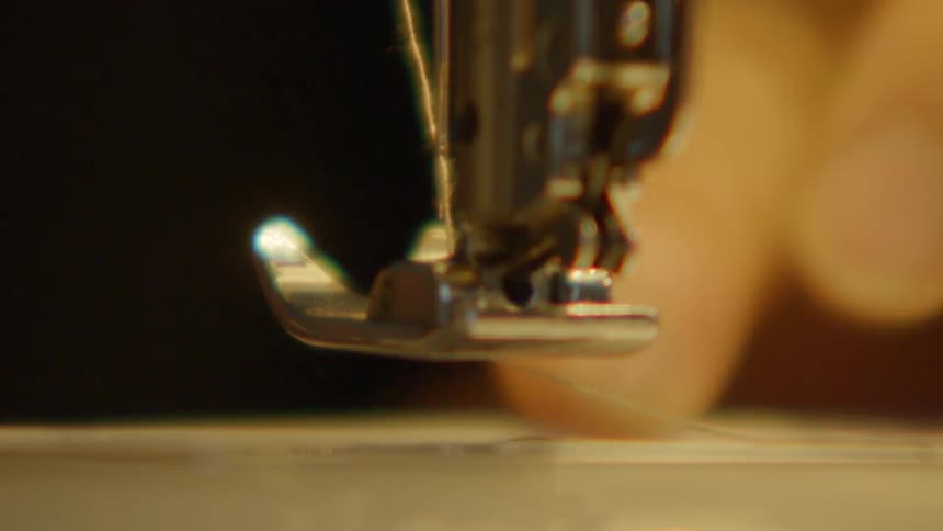 The person puts thread on the sewing machine
