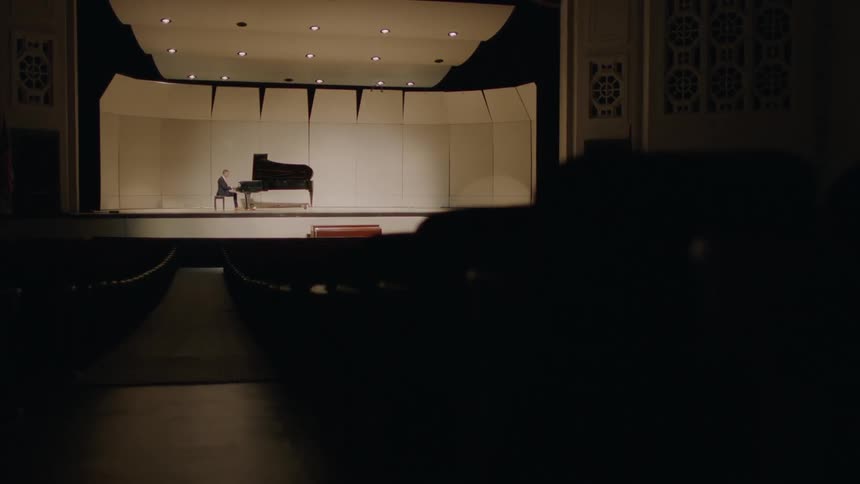 Man plays a piano on stage