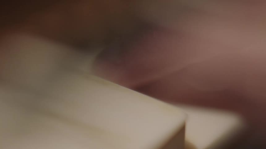 A person is pressing the keys on a piano