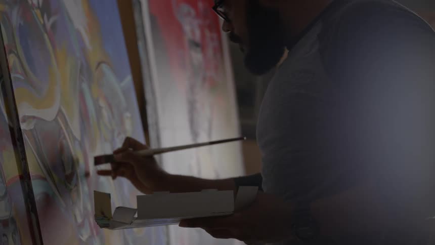 Man paints finishing touches on a painting
