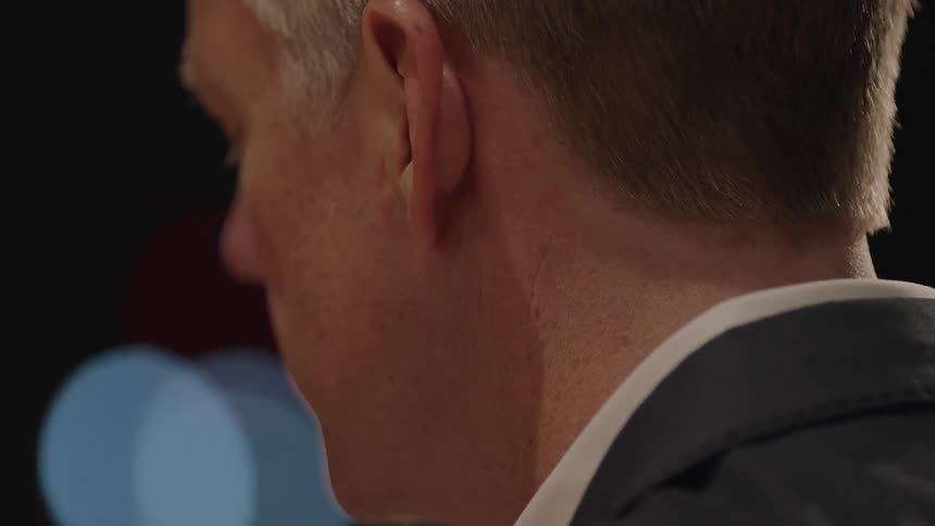 The back of a man's neck and head are shown