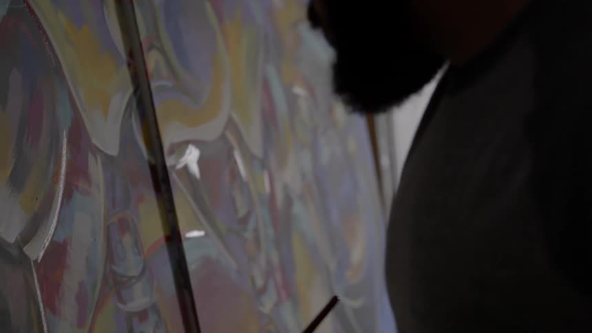 A man is painting in a studio