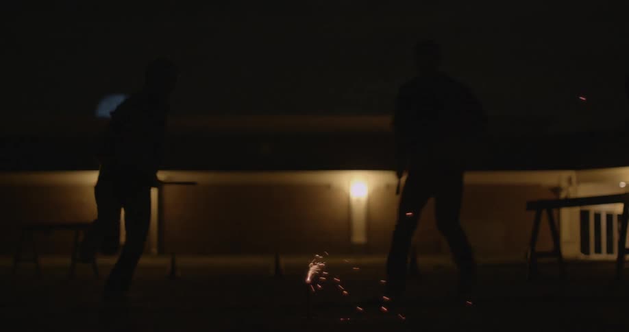 People lighting a firework in the dark