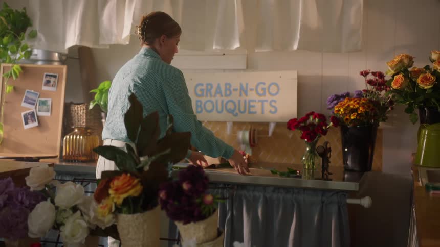 A person wrapping flowers in a store