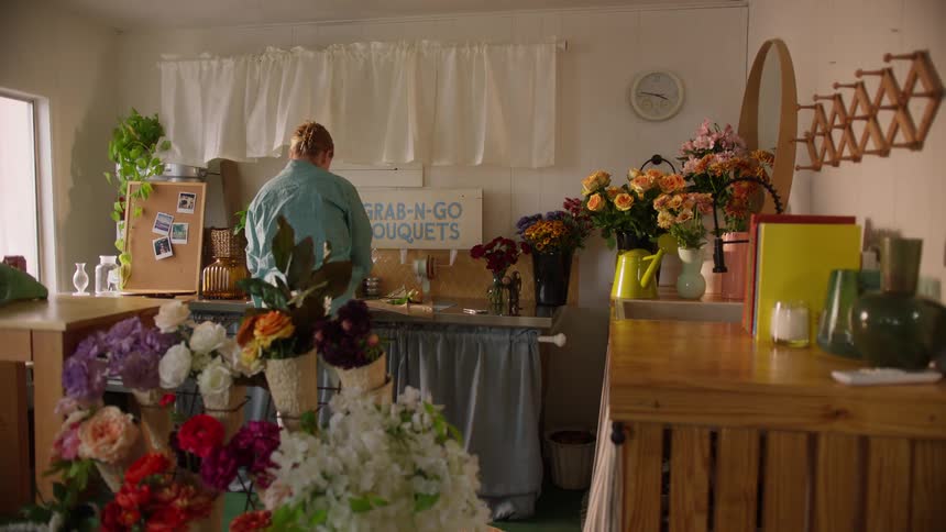 Person arranging flowers at shop