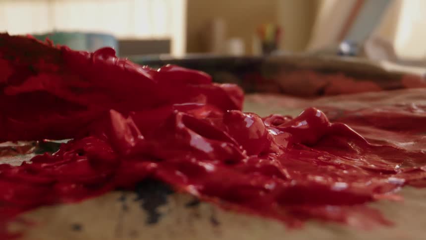 A person mixing paint on a pallet