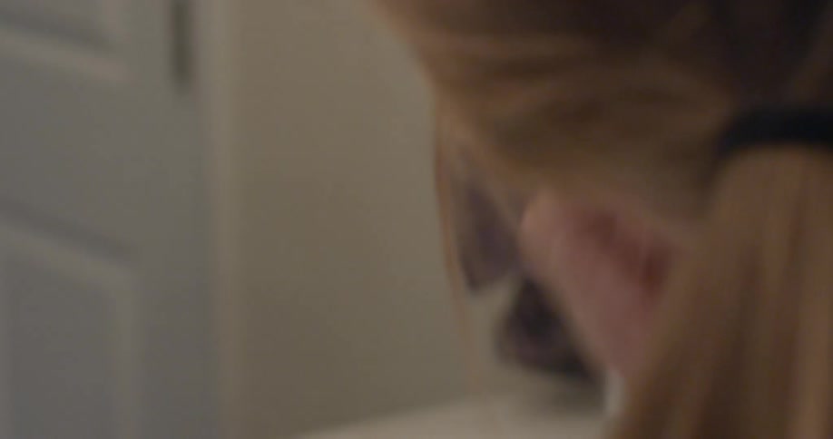 Woman brushing powder on her face in bathroom