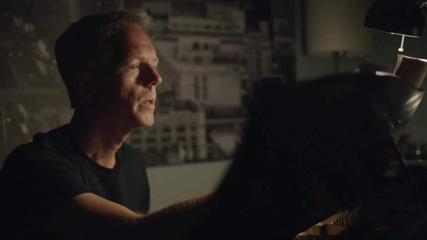 A man looks over something in a dark room