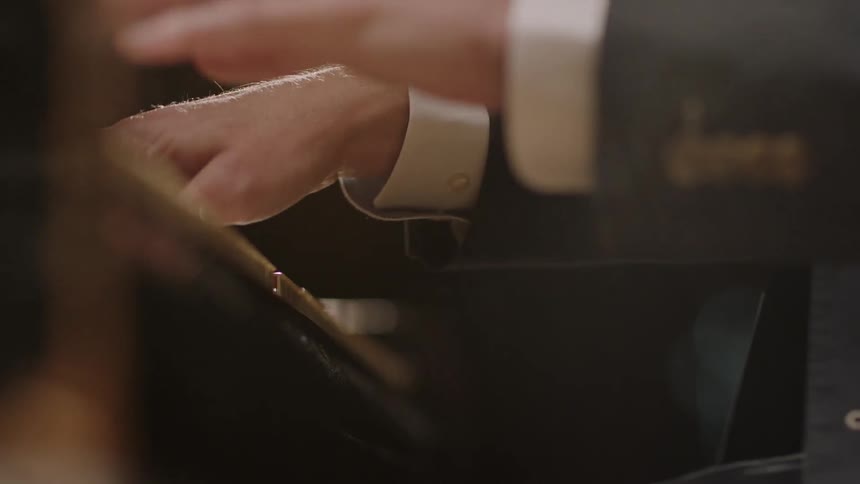 A close up view of a man is playing a piano