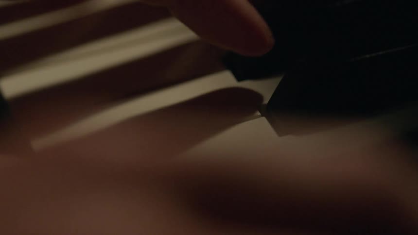 Close up of hand playing piano