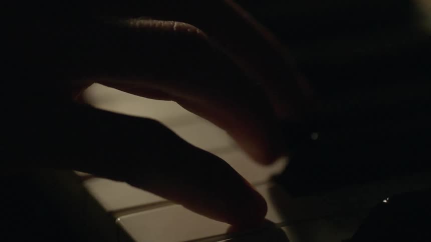 A person is slowly pressing piano keys