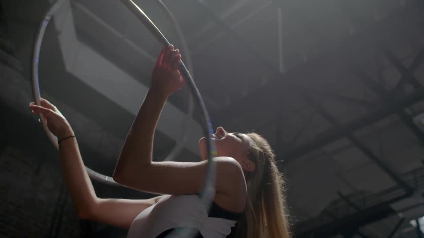 A woman is twirling hula hoops in her arms