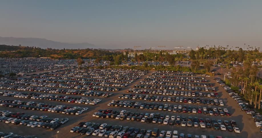 A sprawling parking lot is filled with numerous parked cars