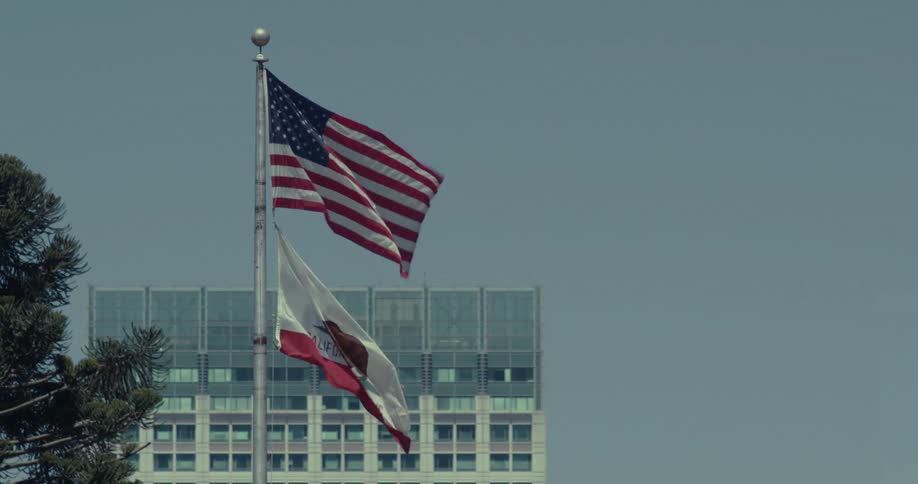 Wind blows the flags of the united states of america and california