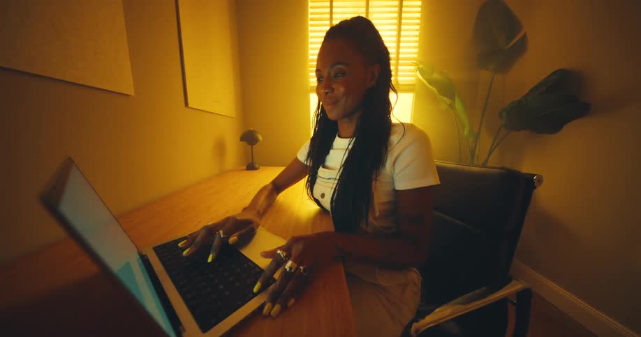 The woman opens her laptop and starts typing