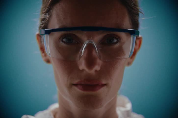 A portrait of a woman wearing safety goggles with flashing light