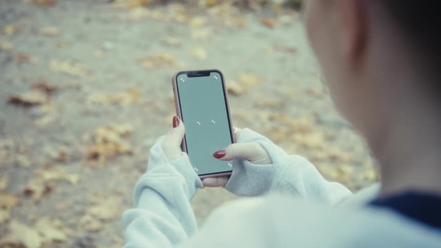 Person with red fingernails using a smartphone