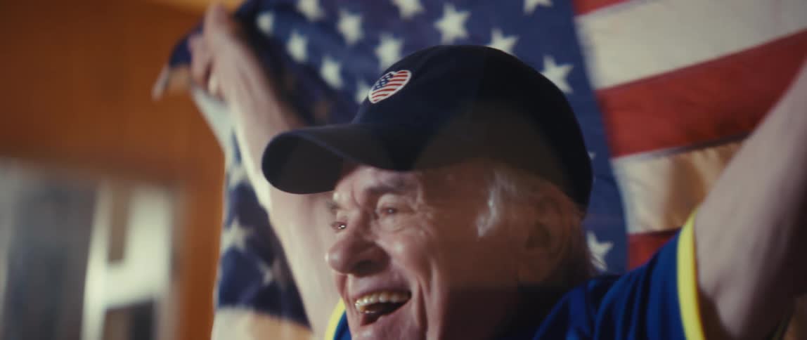 Man celebrates smiling with a raised flag