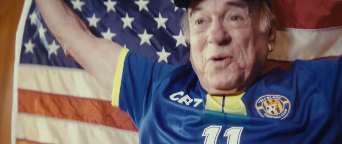 A man standing up and cheering with a flag
