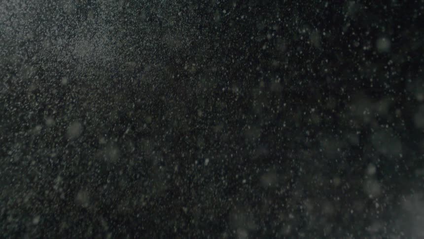 Suspended particles lit from the side against dark background