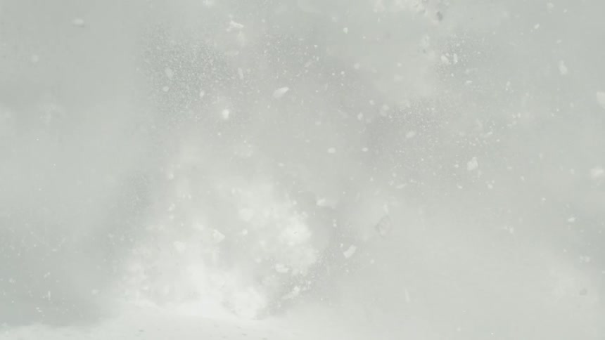 The video begins with a fastmotion shot of a massive plume of white snow powder being kicked up likely by a skier or snowboarder contrasting sharply against a bright blue sky and snowy mountain slope the cloud of snow rapidly engulfs the camera filli