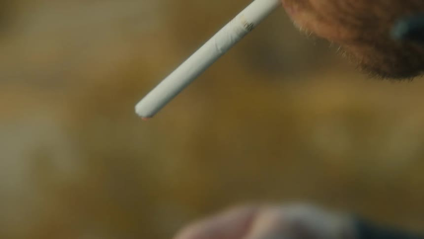 Man lighting a cigarette with a lighter close to his face