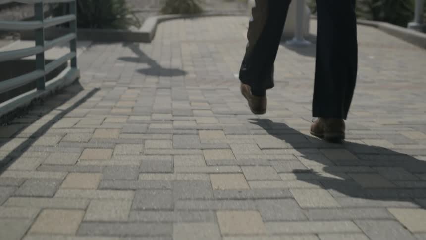 A man walks on a brick path