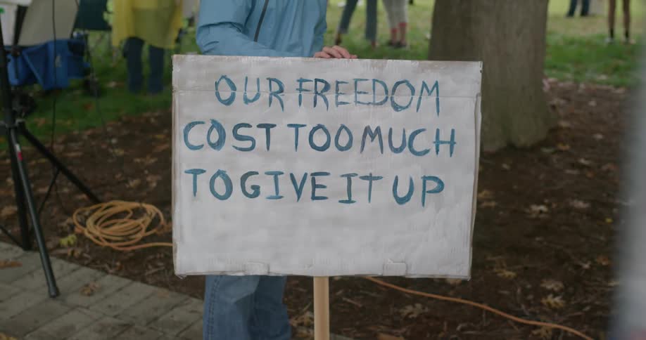 Sign with phrase our freedom cost too much to give it up displayed during park demonstration