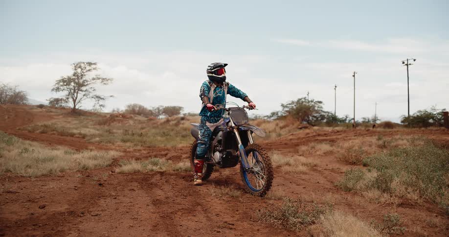 The man looks around on his dirt bike