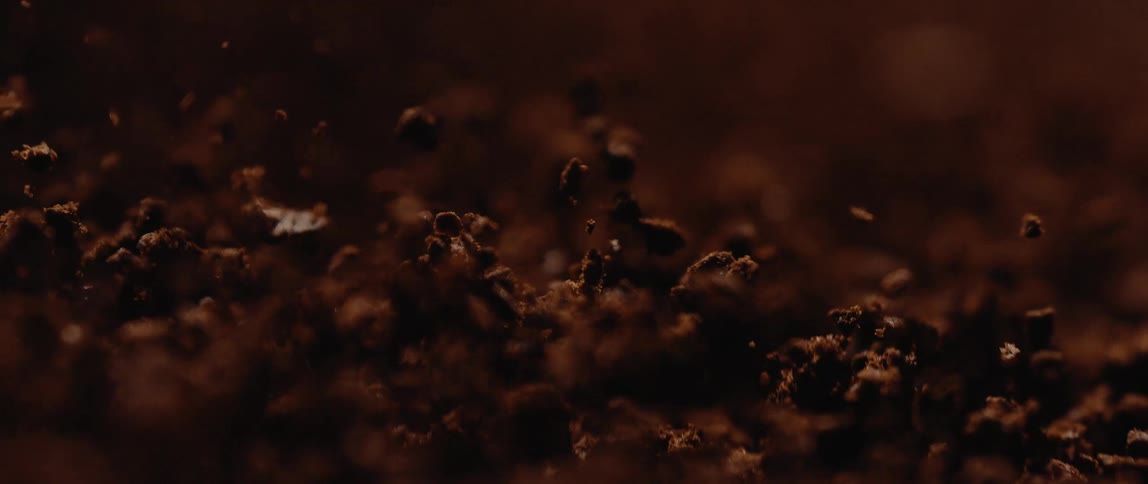 Coffee grounds fall and bounce in a pile