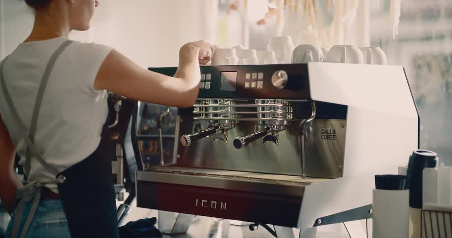 The barista uses the espresso machine