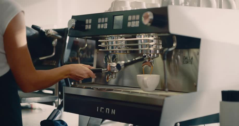 A waiter inside a caf removes a coffee pod from a coffee maker