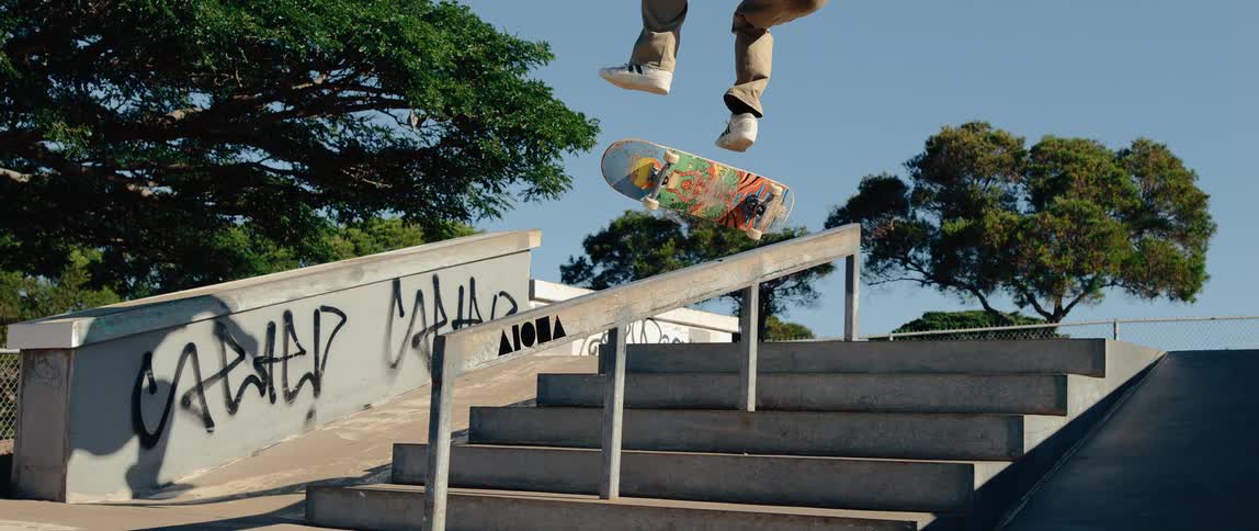 The teenager jumps his skateboard on the stairwell handrail