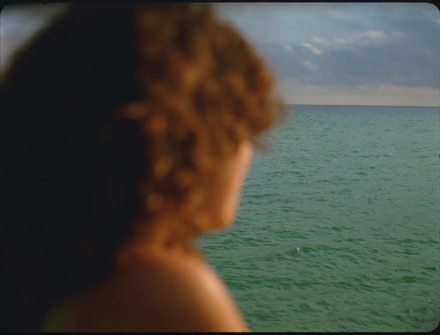 The woman is looking out over the water