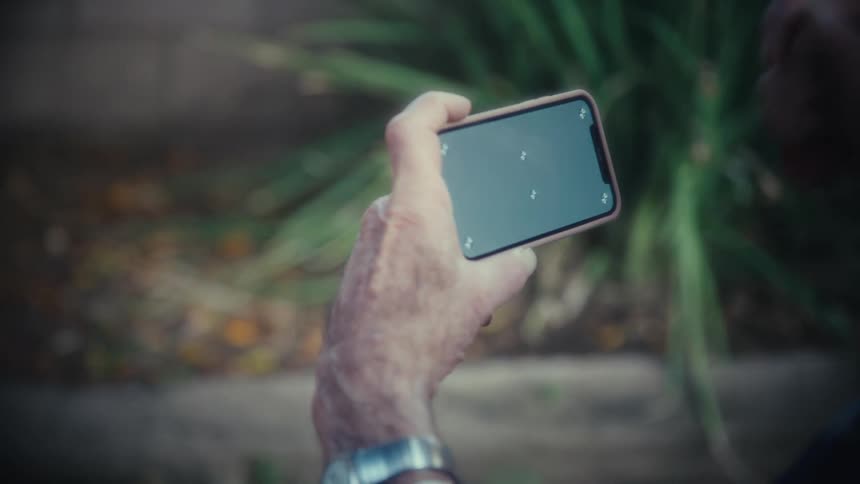 The man is laughing at his cell phone