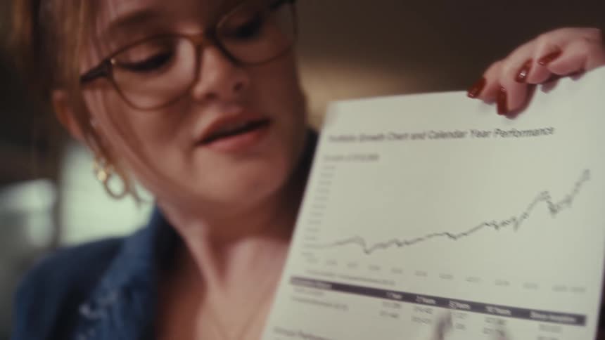 Woman references a printed plot when discussing a portfolio