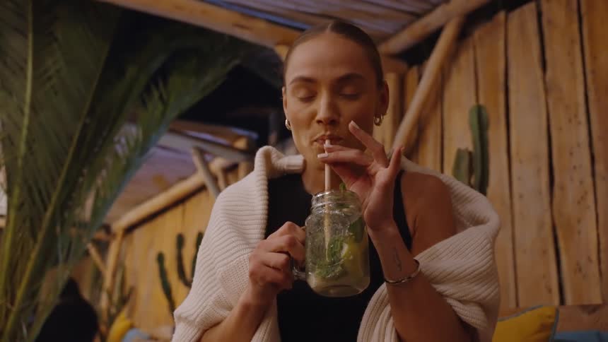 The woman is enjoying a drink outside