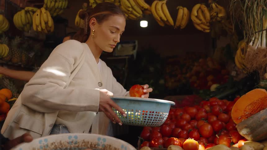 The woman is shopping at the fruit stand