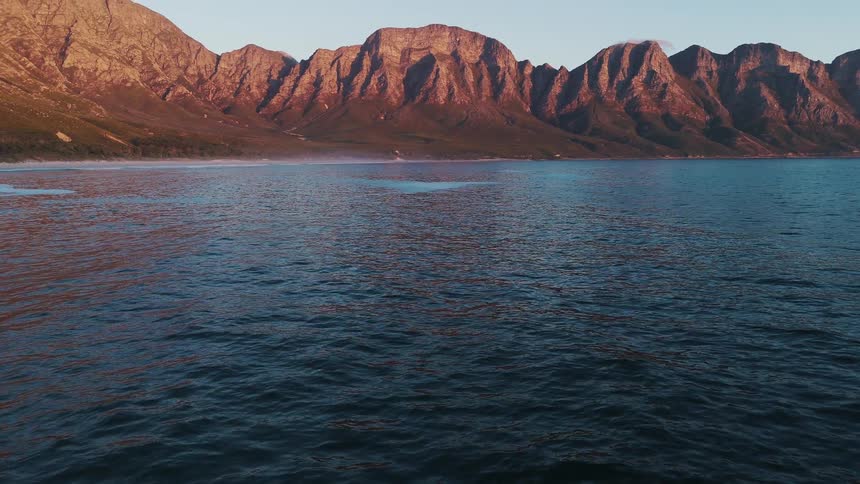 Small waves move on a lake toward shore in the mountains