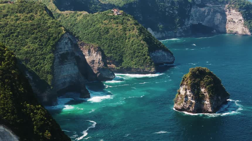 Waves roll into the shores of an island and beaches in a mountain range