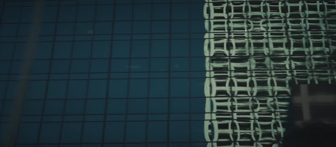 Skyscraper windows reflect other buildings next to them in a city