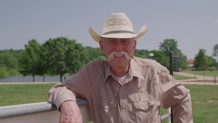The man is smiling on the ranch