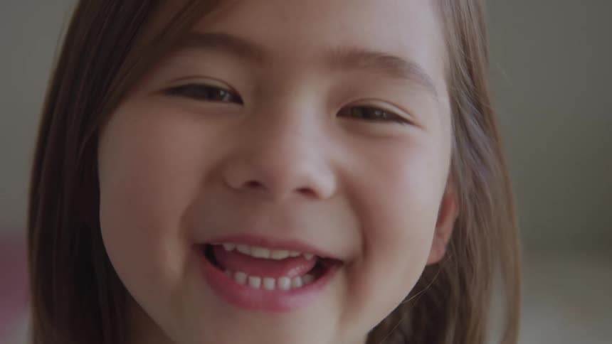 Girl smiles in a closeup showing her teeth