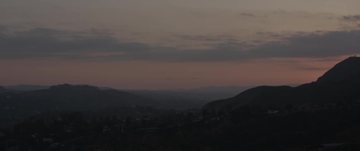 The dawn sky is full of clouds behind these mountains
