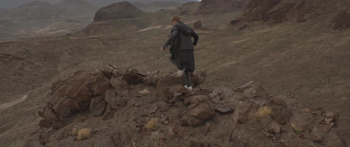Man walks up a rocky cliff