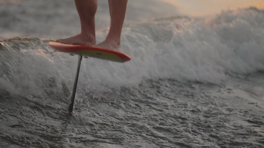 The man is surfing while being pulled by a boat