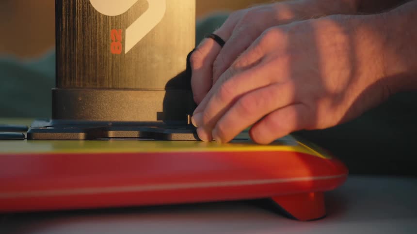 Man adjusts a switch on a machine during the daytime