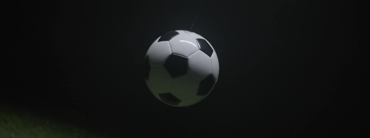 Soccer ball appears suspended in the air under dramatic lighting