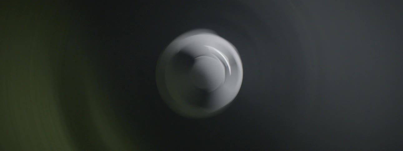 A black and white soccer ball football is suspended in the air against a dark background the ball quickly spins around its vertical axis step printing